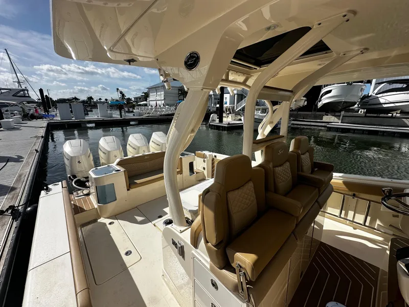 Slide: The Image of 2025 Scout 400 LXF luxury boat interior with seating and multiple outboard engines at a marina. - 21
