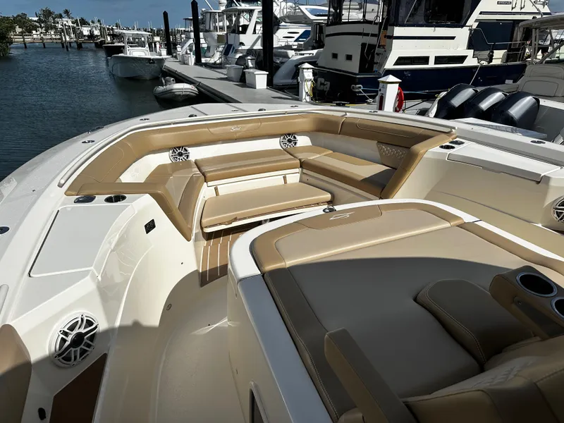 Slide: The Image of 2025 Scout 400 LXF boat interior with tan seating, docked at marina. - 24