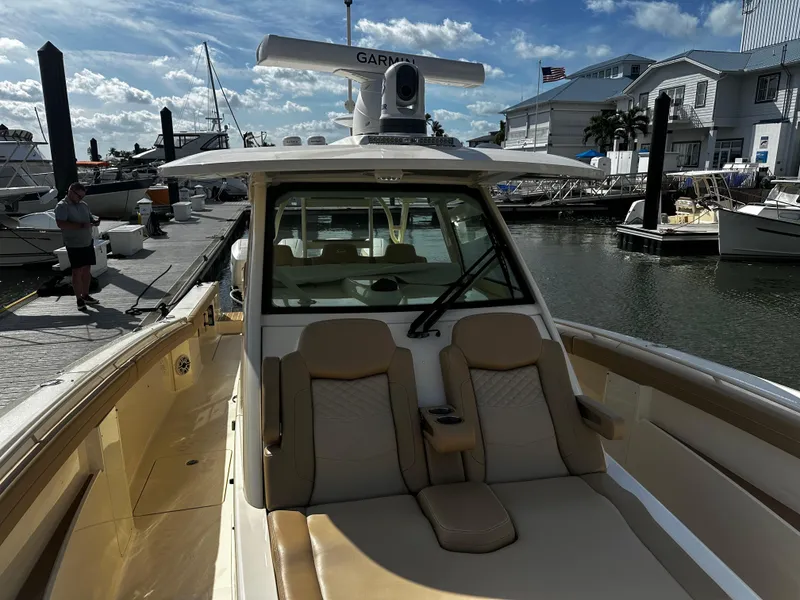 Slide: The Image of 2025 Scout 400 LXF boat docked at marina under blue sky. - 27