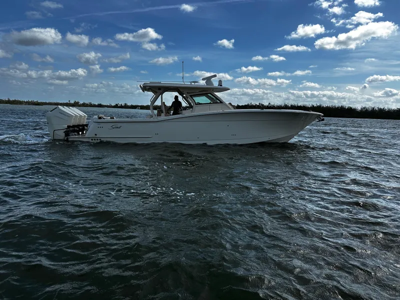 Slide: The Image of 2025 Scout 400 LXF boat cruising on a sunny day with blue skies. - 3