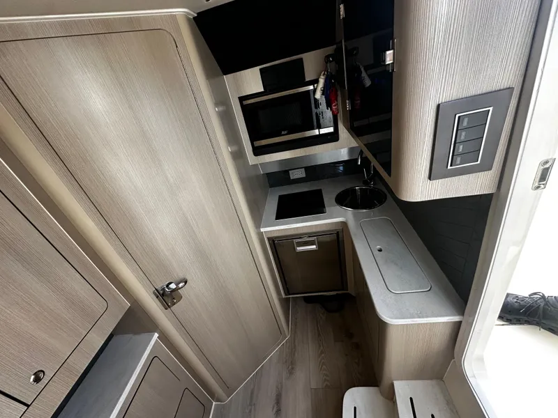 Slide: The Image of 2025 Scout 400 LXF interior kitchen with modern cabinetry and compact design. - 30