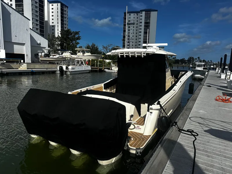 Slide: The Image of 2025 Scout 400 LXF boat docked at marina with covered engines. - 35