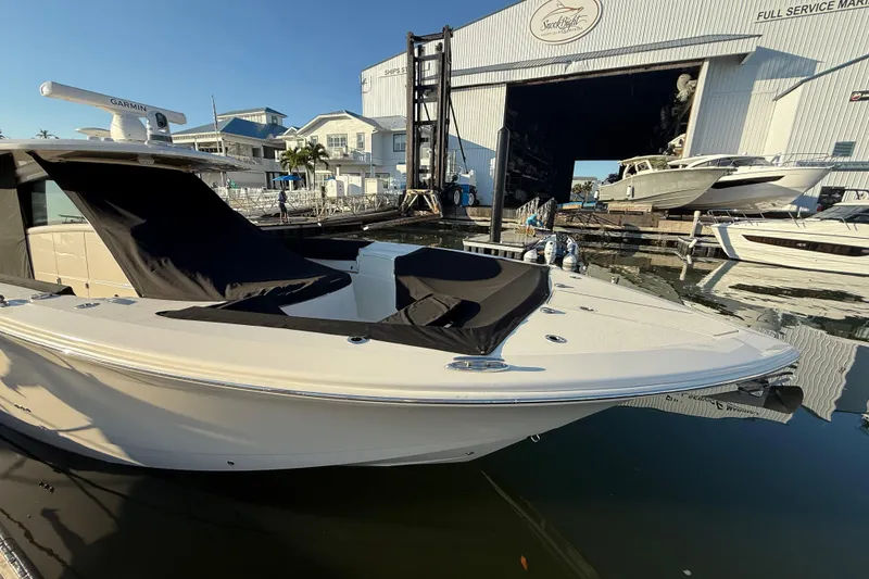 Slide: The Image of 2025 Scout 400 LXF boat docked at marina, with covered seating area. - 36