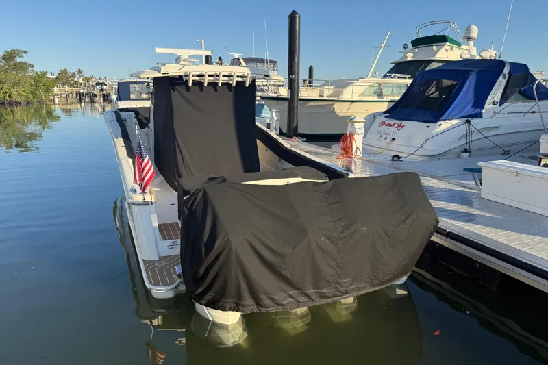 Slide: The Image of 2025 Scout 400 LXF boat docked, covered, with American flag, in marina setting. - 37