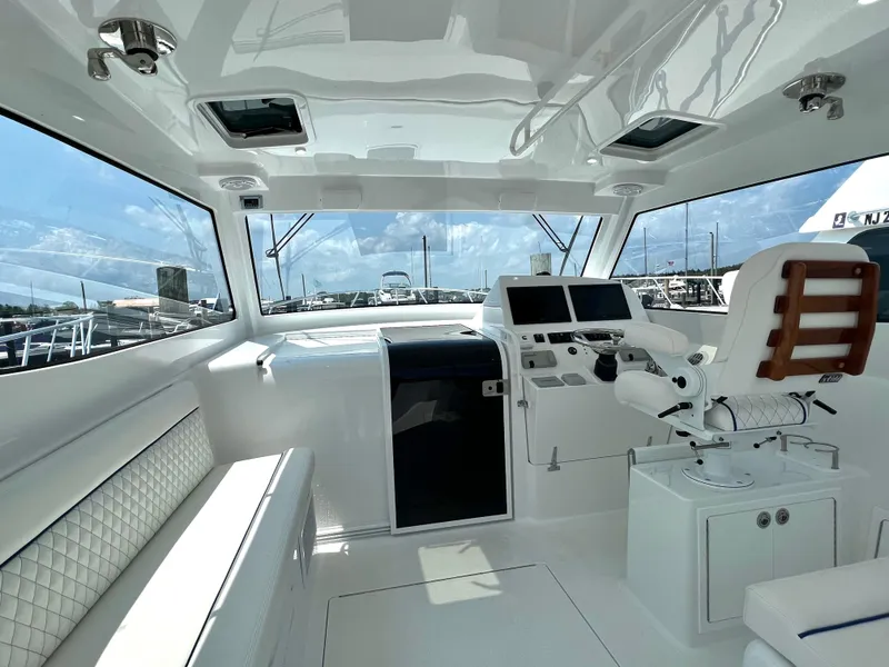 Slide: The Image of 2025 Henriques 35 Express Hardtop interior with helm, seating, and panoramic windows. - 10