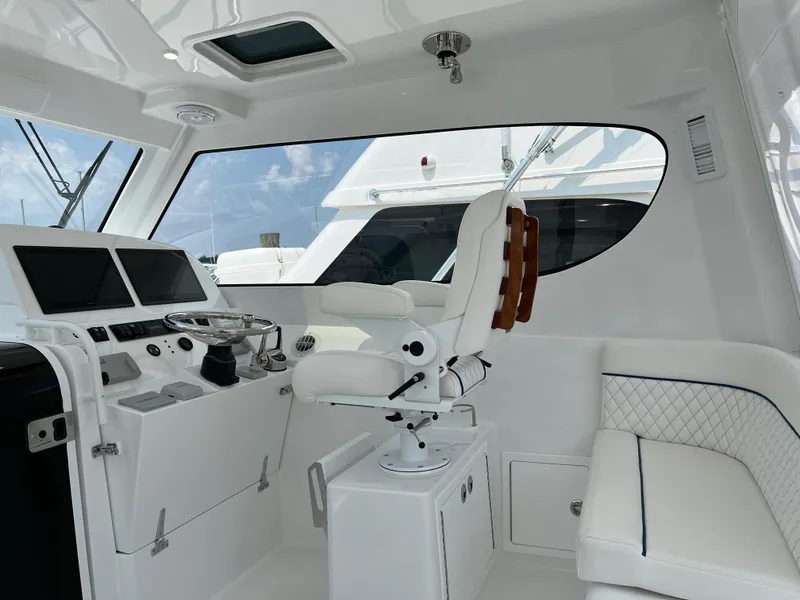 Slide: The Image of 2025 Henriques 35 Express Hardtop interior with helm, seating, and navigation equipment. - 11