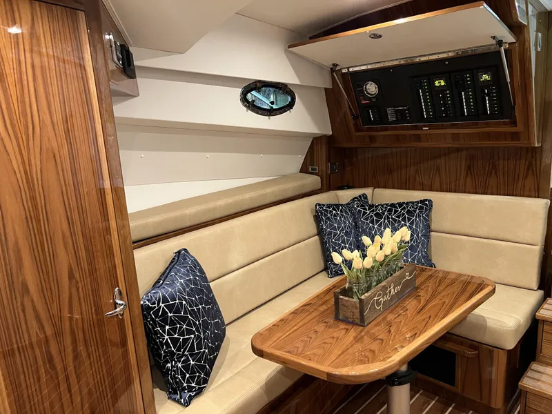 Slide: The Image of Interior of 2025 Henriques 35 Express Hardtop with wood finish and cozy seating area. - 15