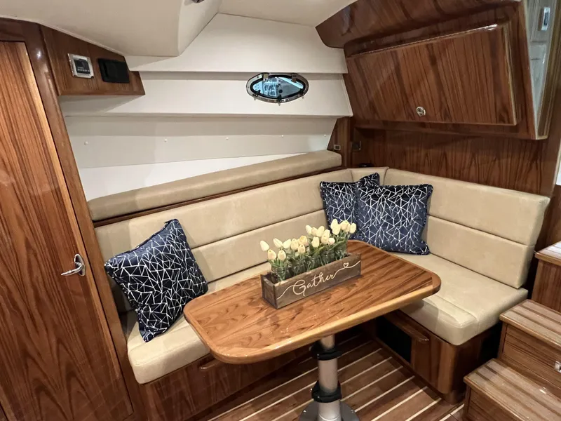 Slide: The Image of 2025 Henriques 35 Express Hardtop cabin with wood interior, beige seating, and decorative pillows. - 16