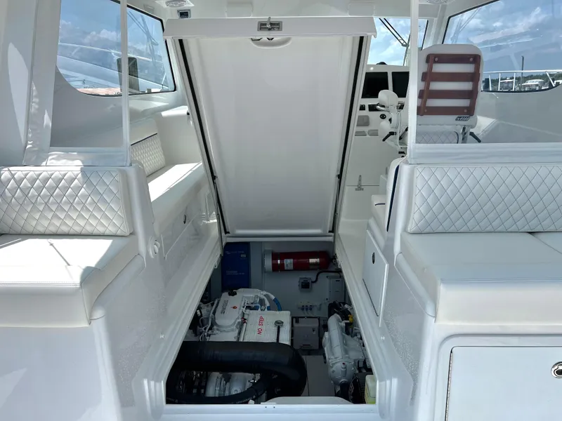 Slide: The Image of 2025 Henriques 35 Express Hardtop interior with open engine compartment, white seating, and control panel. - 26