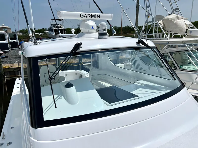 Slide: The Image of 2025 Henriques 35 Express Hardtop boat with Garmin radar, docked at marina. - 32