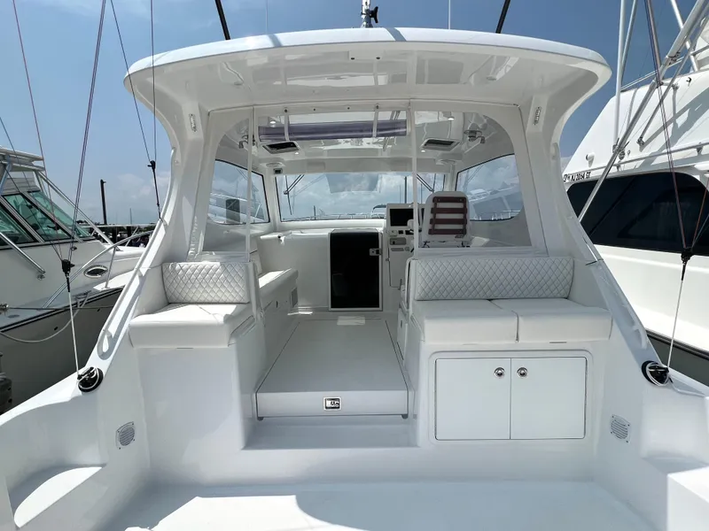 Slide: The Image of 2025 Henriques 35 Express Hardtop boat interior with white seating and modern design. - 7