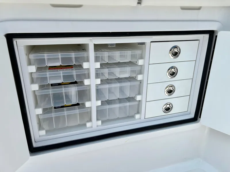 Slide: The Image of Tackle storage compartment on 2025 Henriques 35 Express Hardtop boat, featuring organized drawers and containers. - 8