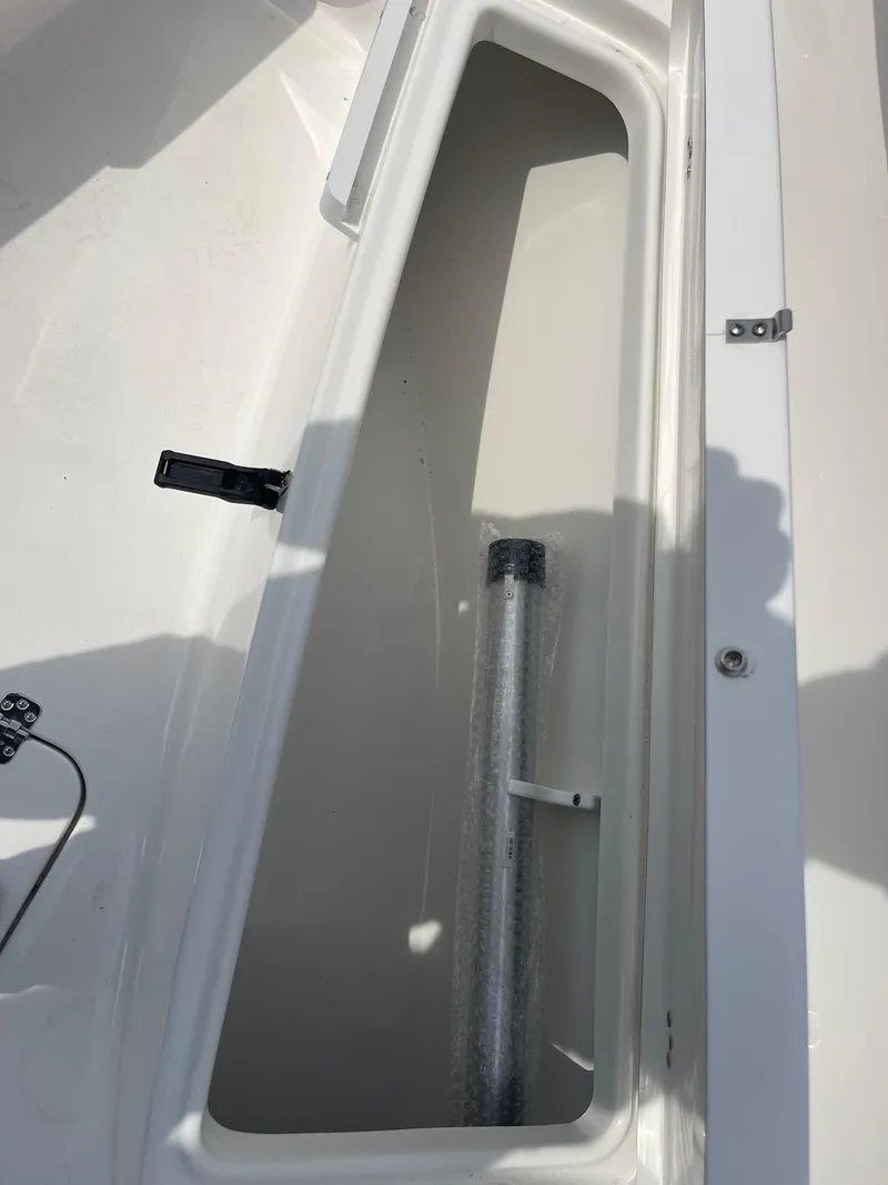 Slide: The Image of 2025 Sea Pro 262 Offshore storage compartment with latch and metal rod. - 50