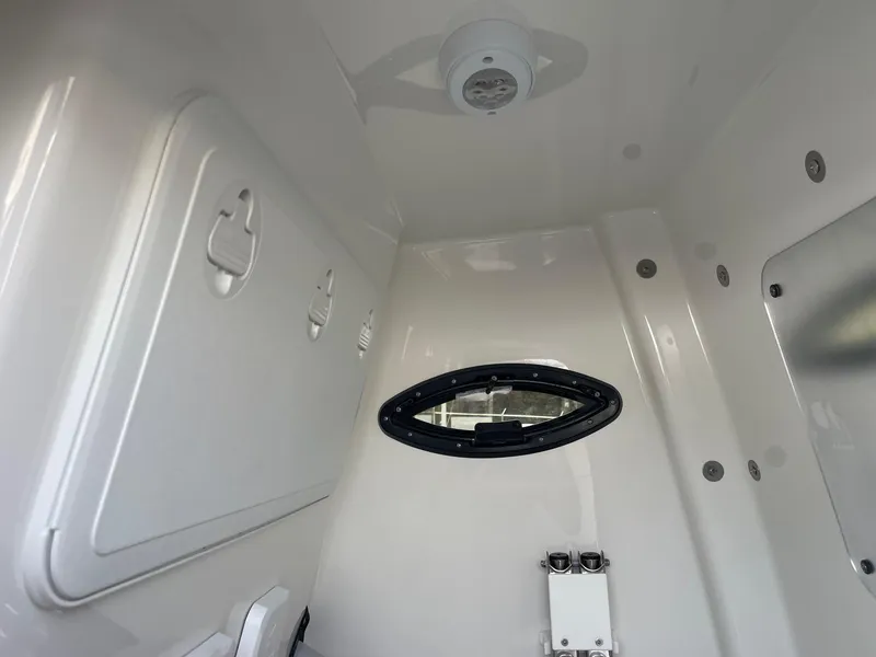 Slide: The Image of 2025 Sea Pro 262 Offshore cabin interior with storage compartments and porthole window. - 53
