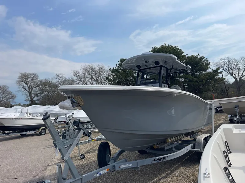Slide: The Image of 2025 Sea Pro 262 Offshore boat on trailer, parked outdoors under a cloudy sky. - 6