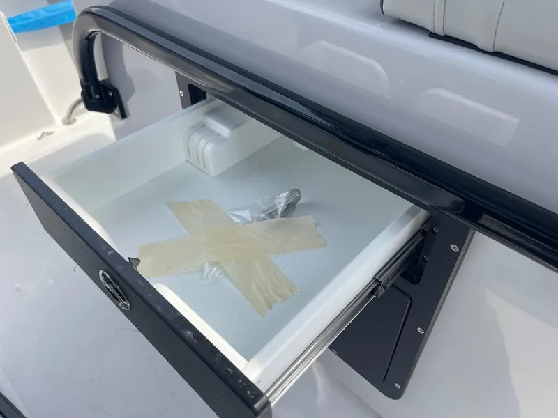 Slide: The Image of Open storage compartment on 2025 Sea Pro 262 Offshore boat with taped items inside. - 60