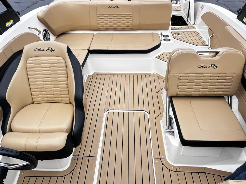 Slide: The Image of 2022 Sea Ray SPX 210 boat interior with tan seating and wood-style flooring. - 3