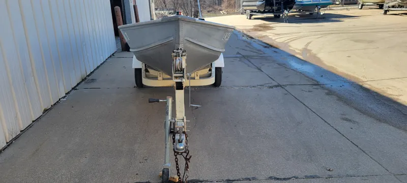 Slide: The Image of 1988 Lowe 14' V boat on trailer, parked outside a building. - 6