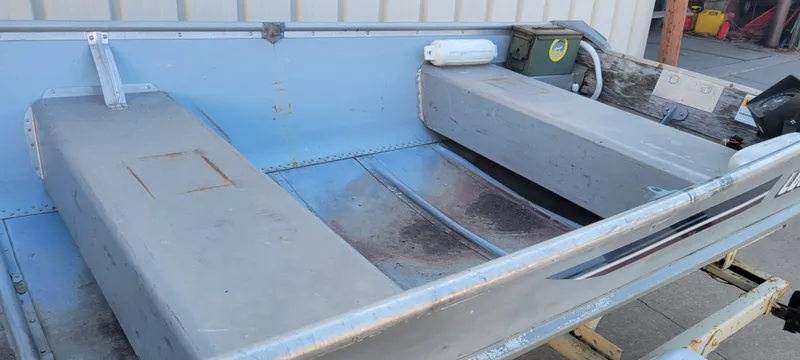 Slide: The Image of 1988 Lowe 14' V boat interior with bench seats and storage compartments. - 8