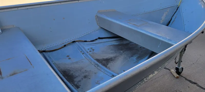 Slide: The Image of 1988 Lowe 14' V boat interior with blue metal seats and flooring. - 14