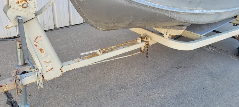 Slide: The Image of 1988 Lowe 14' V boat trailer with visible rust and wear. - 16
