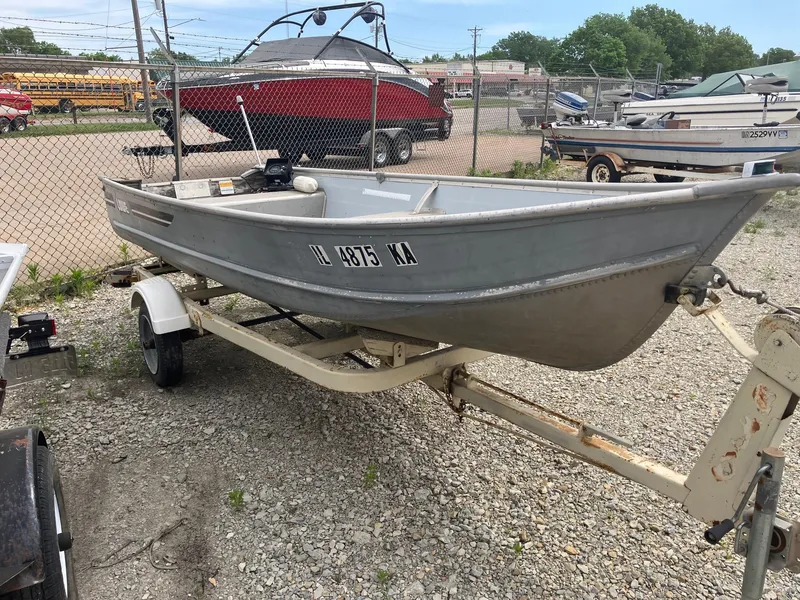 Slide: The Image of 1988 Lowe 14' V boat on trailer in outdoor storage lot. - 3