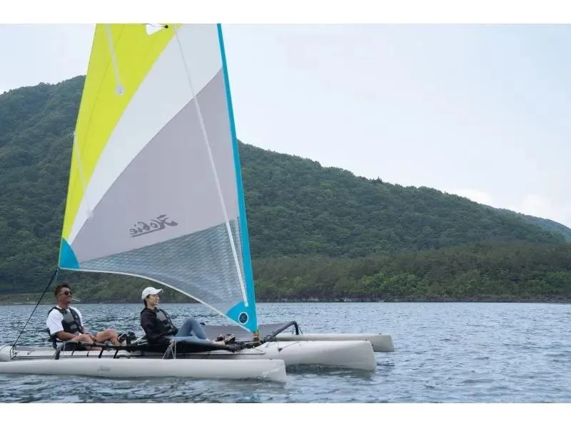 Slide: The Image of Two people sailing a 2012 Hobie Mirage Tandem Island on a scenic lake. - 0