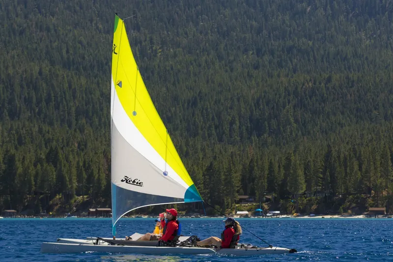 Slide: The Image of 2012 Hobie Mirage Tandem Island sailing on a lake with forested hills in the background. - 1