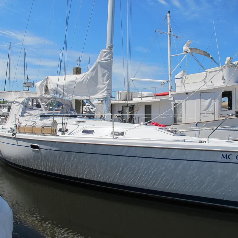 The Image of 1997 Catalina 42 MkII sailboat docked in marina under clear blue sky. - 0