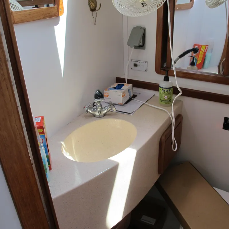 Slide: The Image of Bathroom sink area in a 1997 Catalina 42 MkII sailboat, featuring a countertop and mirror. - 44