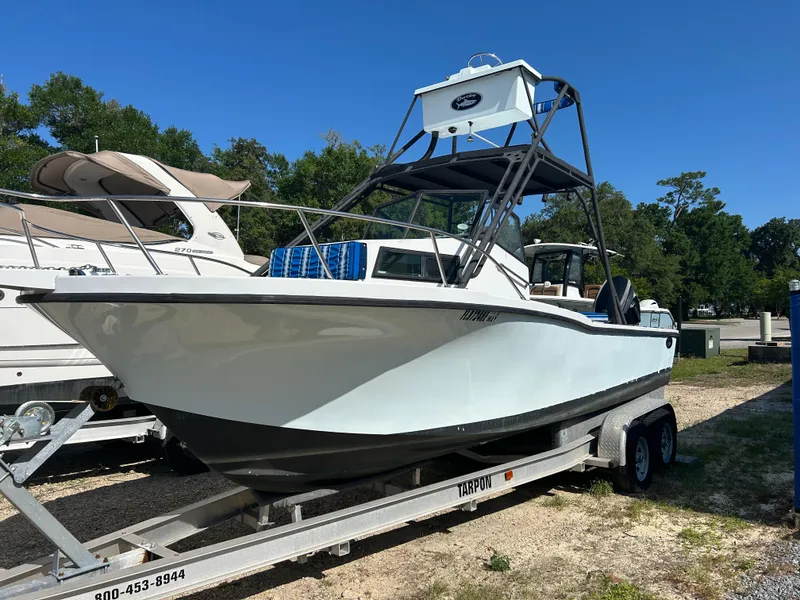 Slide: The Image of 1992 Dusky 256 boat on trailer, parked outdoors under clear blue sky. - 0