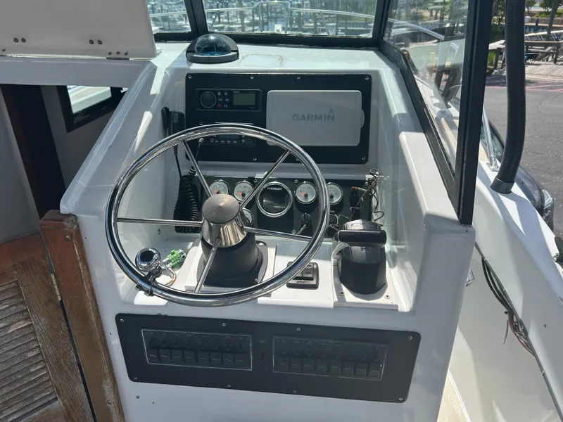 Slide: The Image of Cockpit of 1992 Dusky 256 boat with steering wheel and Garmin navigation system. - 12