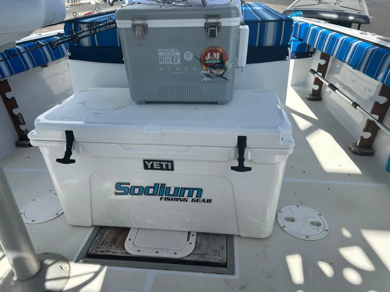 Slide: The Image of Boat interior with Yeti cooler, Sodium Fishing Gear logo, and striped seating. Dusky 256, 1992 model. - 16