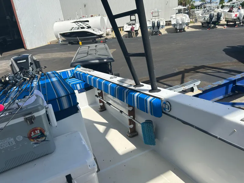 Slide: The Image of 1992 Dusky 256 boat with fishing gear, docked near a warehouse. - 18