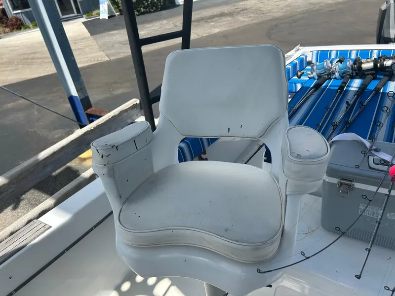 Slide: The Image of White captain's chair on a 1992 Dusky 256 boat, with fishing rods in the background. - 19