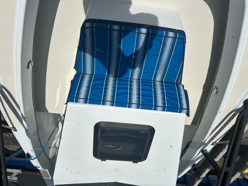 Slide: The Image of 1992 Dusky 256 boat with blue striped seating and storage compartment. - 20