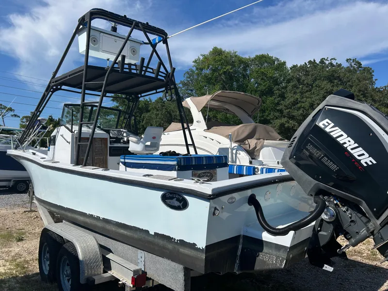 Slide: The Image of 1992 Dusky 256 boat with Evinrude engine on trailer, parked outdoors. - 3