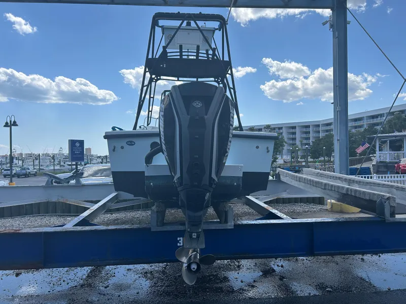 Slide: The Image of Dusky 256 boat from 1992 on a lift at a marina, under a partly cloudy sky. - 4