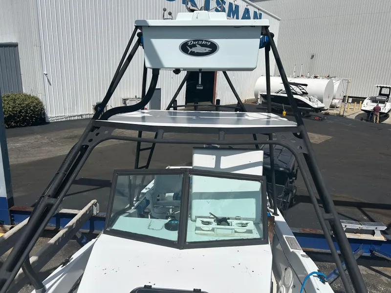 Slide: The Image of Dusky 256 boat from 1992 with a sturdy frame and windshield, parked outdoors. - 5