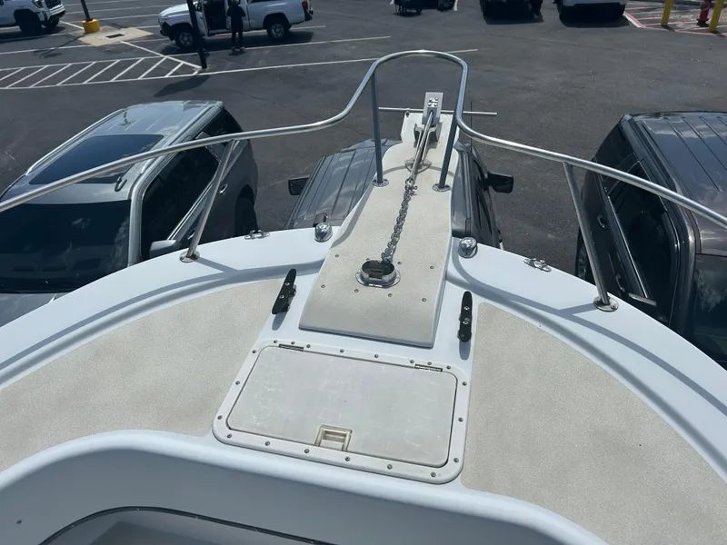 Slide: The Image of Bow of a 1992 Dusky 256 boat with anchor chain, parked in a lot. - 7