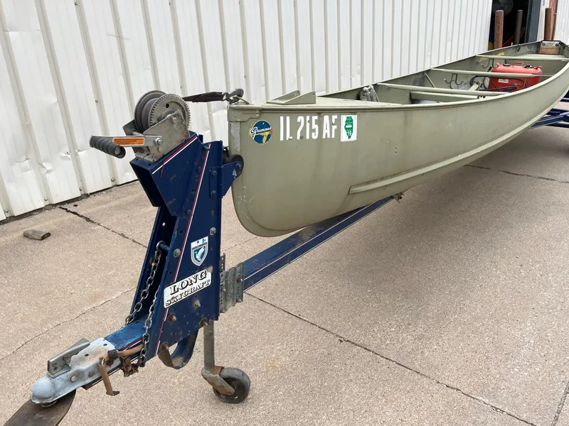 Slide: The Image of 1961 Grumman 19' Square Stern Canoe on trailer, parked beside a white building. - 13