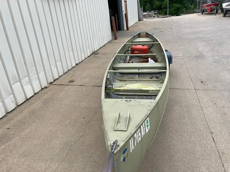 Slide: The Image of 1961 Grumman 19' Square Stern Canoe on concrete near a building. - 4