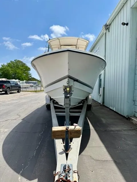 Slide: The Image of 2001 Regulator 26 Forward Seating boat on trailer, parked outdoors near a building. - 5