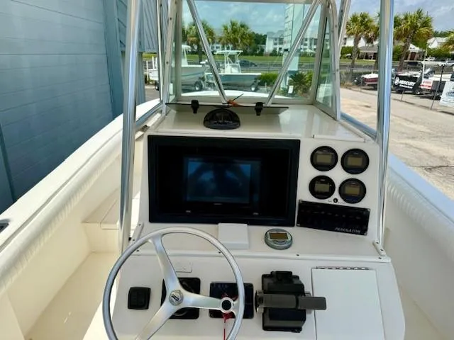 Slide: The Image of 2001 Regulator 26 Forward Seating boat dashboard with steering wheel and navigation instruments. - 6