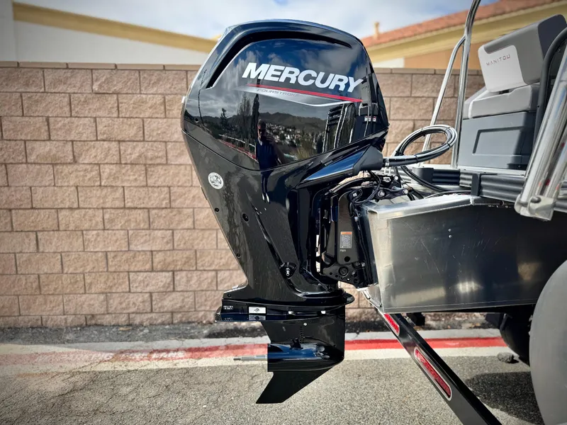 Slide: The Image of Outboard motor on 2025 Manitou Cruise 20 Bench Twin Tube boat, featuring Mercury branding. - 7