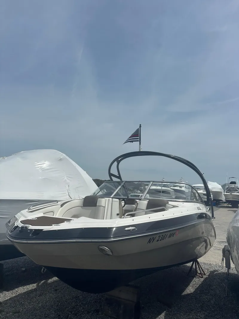 Slide: The Image of 2013 Yamaha Boats 242 Limited S on display in a boatyard under a clear sky. - 1