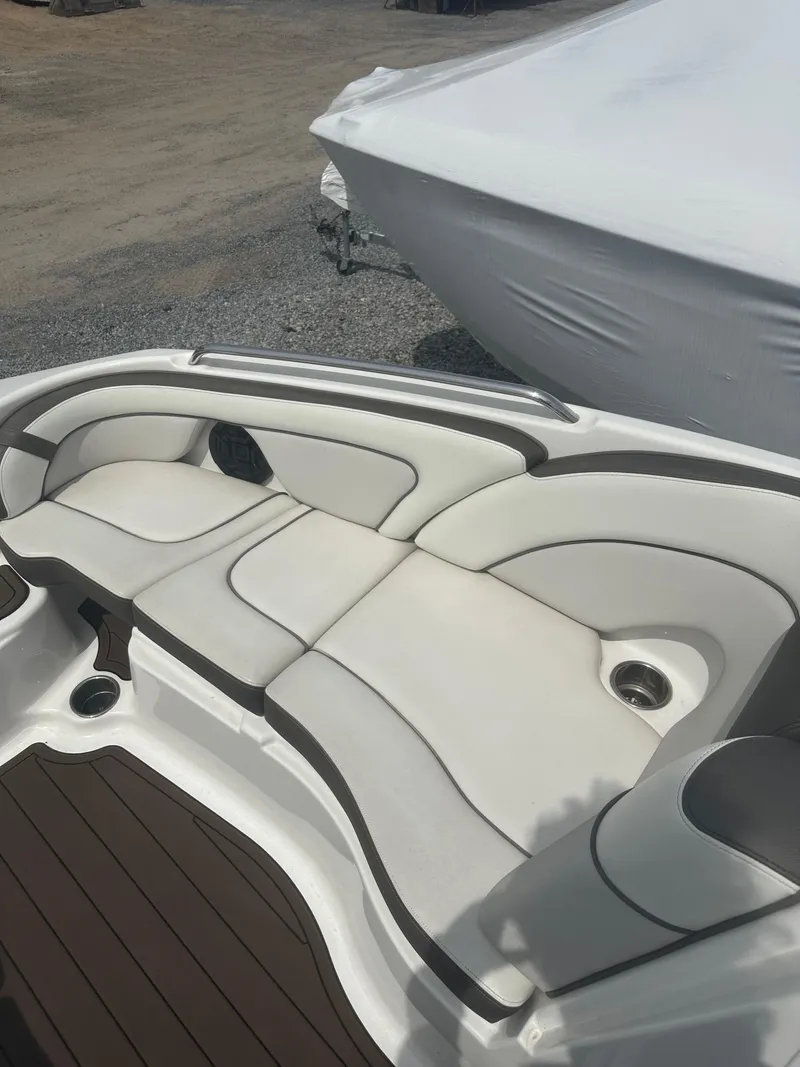 Slide: The Image of 2013 Yamaha Boats 242 Limited S interior seating with white and gray upholstery. - 10