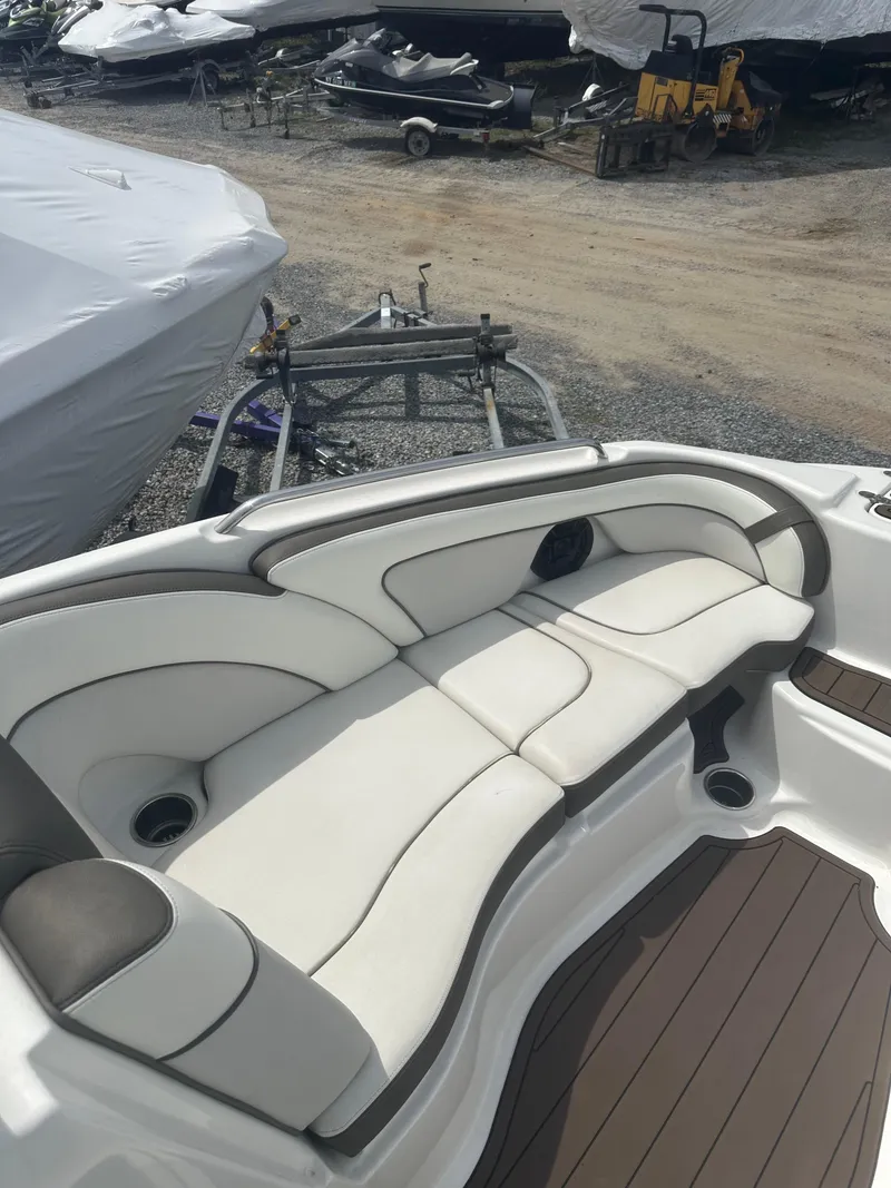 Slide: The Image of 2013 Yamaha Boats 242 Limited S with white cushioned seating and wood-style flooring. - 11