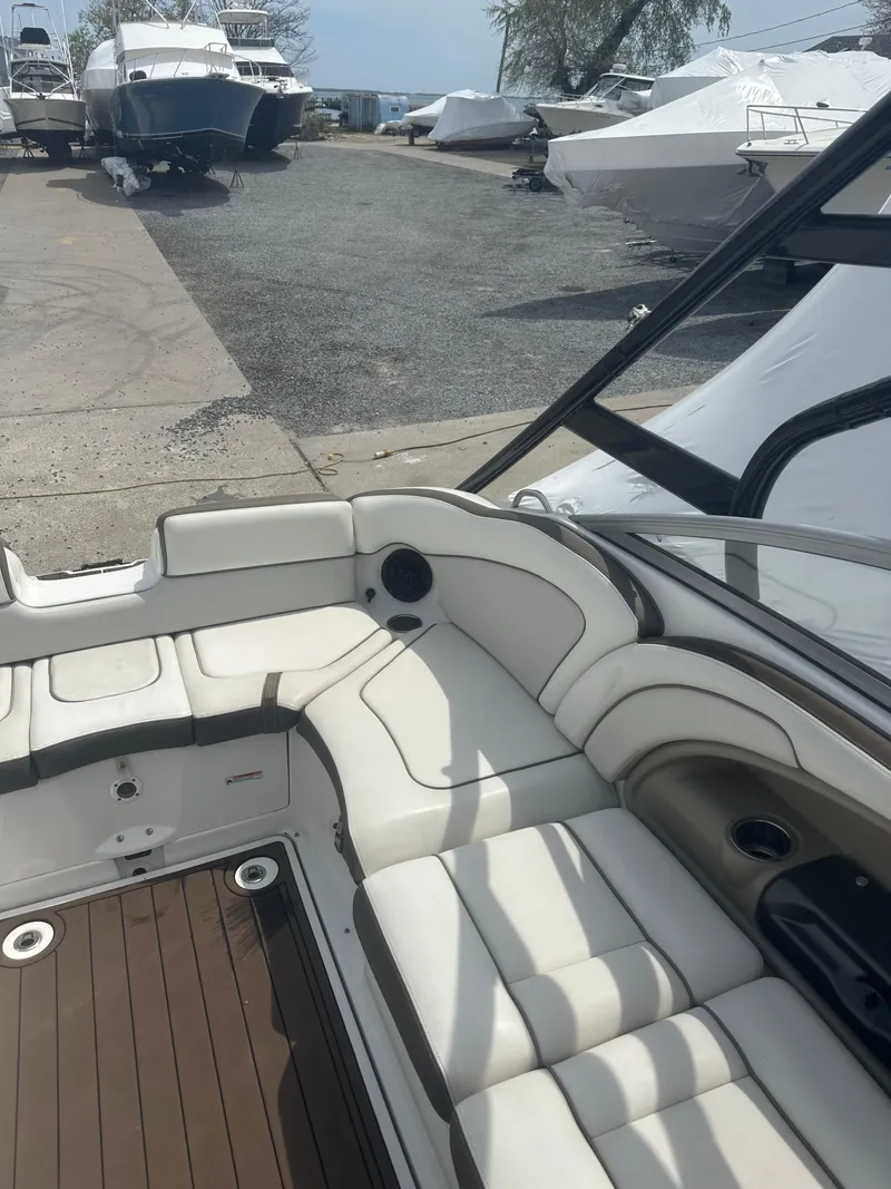 Slide: The Image of 2013 Yamaha Boats 242 Limited S with spacious seating and sleek design in a marina setting. - 16