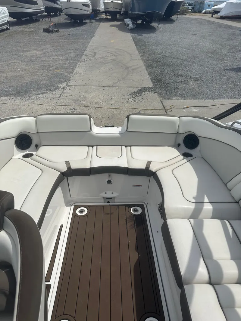 Slide: The Image of 2013 Yamaha Boats 242 Limited S interior with white seating and wood flooring. - 7